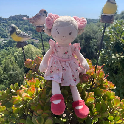 Vendela rag doll with pink floral dress, pink bows, and red shoes