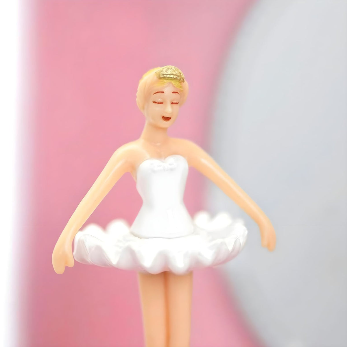 Pormenor da figura de bailarina com tutu branco no interior da caixa musical