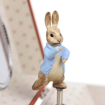 Pormenor da figura de Peter Rabbit com casaco azul no interior da caixa de música Cenoura