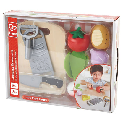 Child playing with Hape children's cooking set with chopping board, vegetables, and utensils