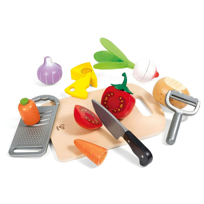 Child playing with Hape children's cooking set with chopping board, vegetables, and utensils
