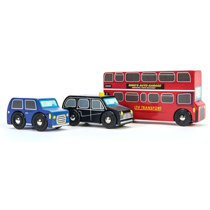 Child playing with Le Toy Van's London Vehicles wooden set with red bus, black taxi, and blue car