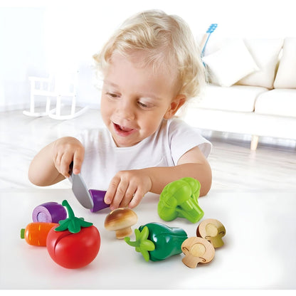 Child playing with Hape wooden vegetable set and toy knife