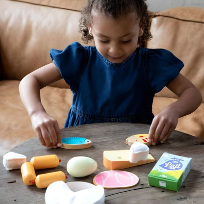 Child playing with Vilac wooden food set with play food and milk carton