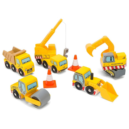 Child playing with Le Toy Van wooden construction vehicles, including truck, crane, excavator, loader, and cones.
