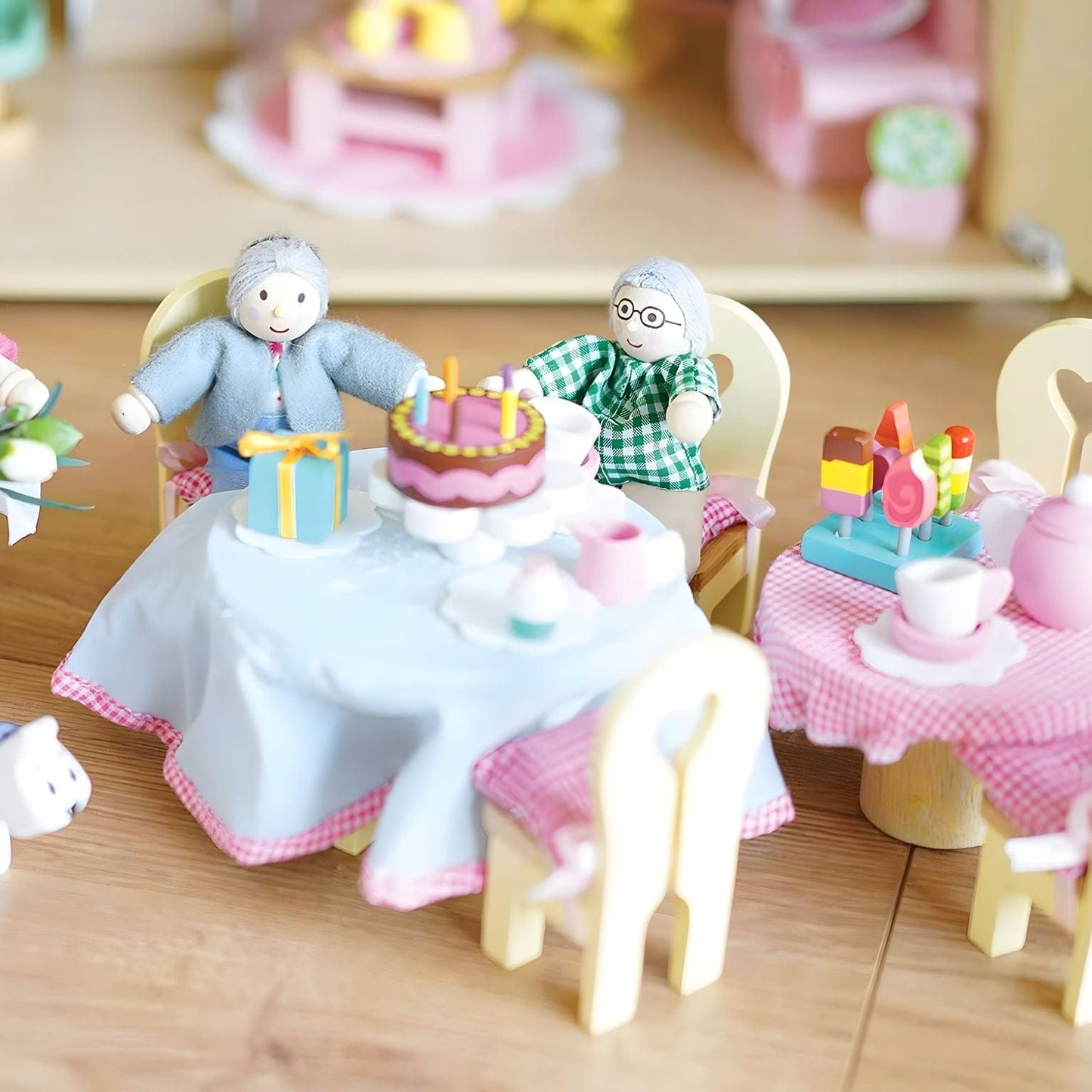 Conjunto figuras Daisylane - Avós da Le Toy Van com dois avós numa cena de festa e casa de bonecas