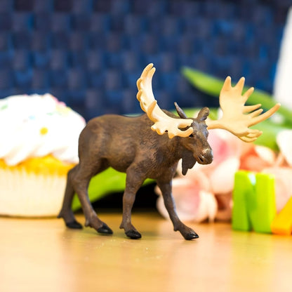 Figura de borracha Alce sobre uma mesa junto a um queque