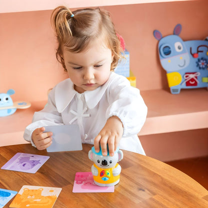 Child playing with "I Learn" Game: "I Learn with Coco" by Diset with illustrated cards and interactive doll
