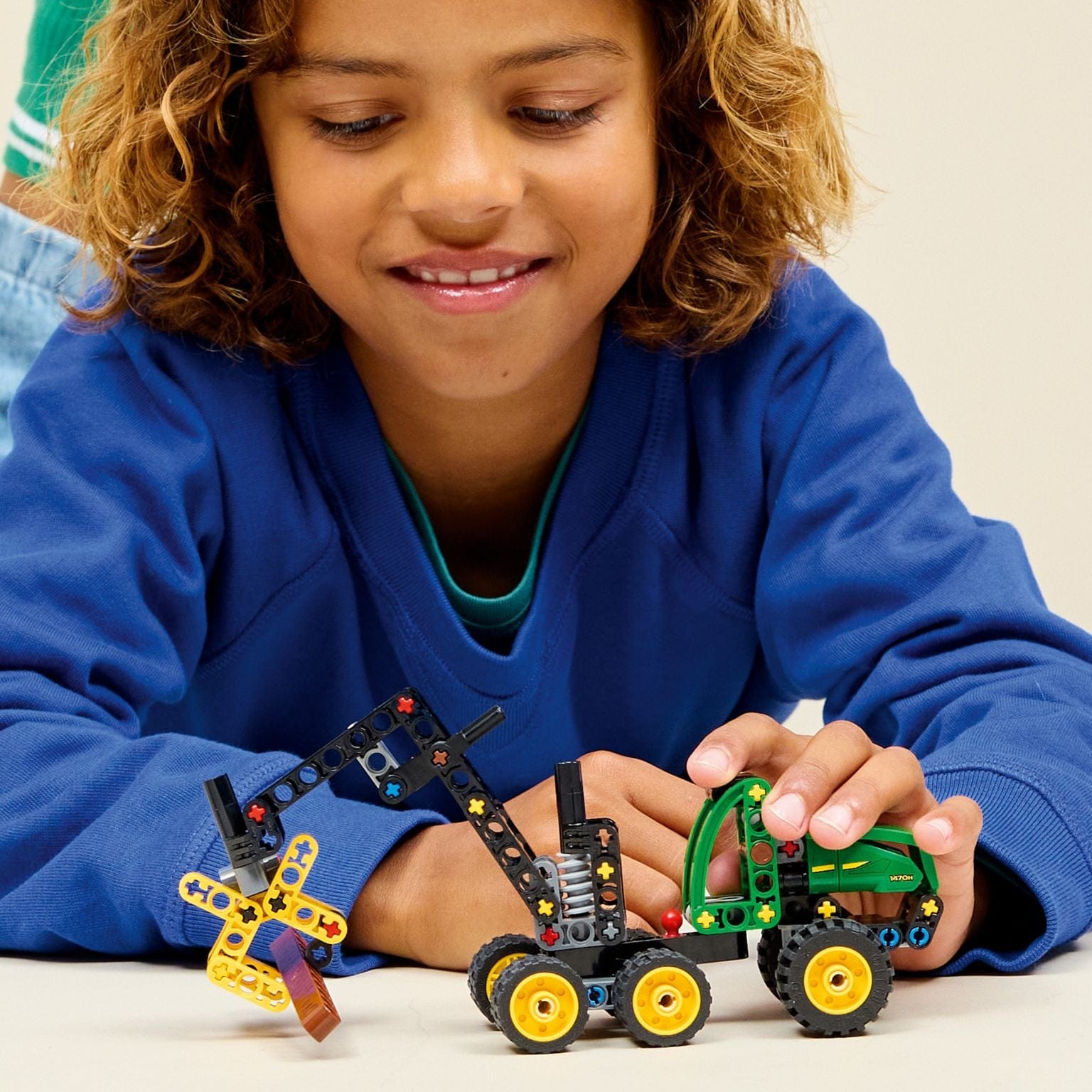 Lego Technic Ceifeira com Rodas John Deere 1470H verde e amarelo com braço articulado e garra a segurar troncos